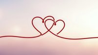 Two intertwined red heart shapes connected by flowing lines on soft pink gradient background for romantic love concept and Valentine's Day designs.