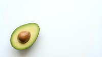 Fresh ripe avocado half with pit on clean white background isolated for healthy cooking and nutrition design projects.
