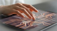 Hand touching futuristic holographic interface with glowing circuit patterns on tablet screen representing advanced technology and digital innovation concepts.