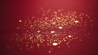 Golden sparkles and glitter particles scattered on deep red burgundy background creating luxury festive atmosphere for holiday celebrations and events.
