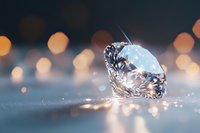Brilliant cut diamond with light reflections on blue surface against blurred bokeh background for luxury jewelry advertising.