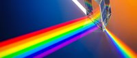 Crystal prism dispersing white light into vibrant rainbow spectrum on gradient background for physics education and optical science concepts.