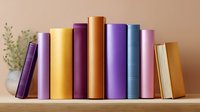 Row of colorful hardcover books standing on wooden shelf with decorative plant, creating cozy home library atmosphere for reading and education background.
