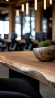 Wooden bowl with green plant on natural wood table in modern restaurant interior with warm pendant lighting and blurred dining area background.