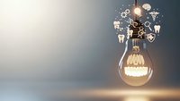 Glowing light bulb with creative icons floating above representing innovation, ideas, brainstorming and business creativity concepts for marketing materials.
