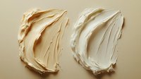 Textured cream and white cosmetic smears showing rich moisturizer or foundation texture on beige background, demonstrating product consistency for beauty marketing.