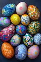 Colorful decorated Easter eggs with intricate floral and geometric patterns painted in vibrant colors on dark background, showcasing traditional holiday craftsmanship.