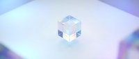 Transparent glass cube with iridescent light refraction on white surface, suitable for tech, design, and abstract backgrounds.