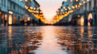 Atmospheric urban street with festive string lights reflecting on wet pavement at sunset, creating a magical bokeh effect in the evening cityscape.