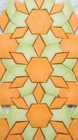 Cantaloupe and honeydew melon slices arranged in a geometric mosaic pattern on marble, creating a colorful fresh fruit art display.