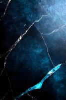 Dark marble texture with glowing blue cracks and veins on black background creates dramatic abstract pattern for luxury design and decoration purposes.