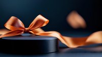 Elegant black round gift box with luxurious copper satin ribbon bow against dark background. Romantic present packaging with flowing silky decoration.