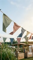 Colorful fabric bunting flags hanging outdoors against soft sky for party celebration wedding festival decoration rustic garden event planning.