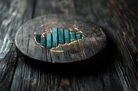 Turquoise crystal bars arranged in ascending order on dark wooden circular platform with gold leaf accents, creating mystical minimalist composition on rustic surface.