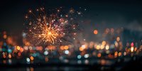 Vibrant fireworks exploding against night sky with colorful bokeh city lights in background creating festive celebration atmosphere.