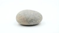 Smooth gray granite pebble stone isolated on white background for zen meditation, spa decoration, landscaping and natural design projects.