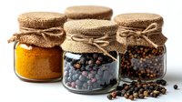 Glass jars with aromatic spices and peppercorns covered with burlap and twine on white background, natural cooking ingredients in rustic style presentation.