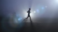 Athletic woman runner silhouette jogging through dramatic fog with bright lens flares creating moody fitness atmosphere for sports motivation content.