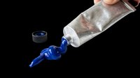 Metallic tube pouring vibrant blue liquid paint or ink isolated on transparent background. Ready for design use on t-shirts, stickers, clipart, print-on-demand products, and sublimation projects.