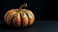 Decorative autumn gourd with golden striped pattern isolated on dark background, suitable for fall seasonal designs, harvest themes, and holiday marketing materials.