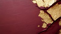 Luxurious burgundy and gold abstract background with cracked texture effect, metallic gold leaf fragments on deep red surface creating elegant contrast.