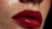Close-up of woman's glossy red lips with luxurious shine, perfect for beauty and cosmetics advertising campaigns.