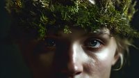 Young person wearing natural moss and foliage crown, with intense gaze in dramatic lighting, evoking forest mythology and connection to nature.
