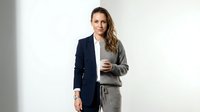 Professional businesswoman in split formal and casual attire holding coffee cup against white background for corporate lifestyle concepts.