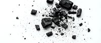 Shattered black coal or charcoal fragments and dust particles scattered across white background, depicting destruction, energy resources, or industrial materials for design and editorial use.
