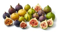 Fresh figs collection with whole and sliced fruits showing colorful varieties including purple, green and yellow types on white background.