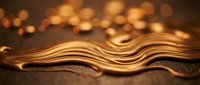 Elegant golden waves flowing across dark surface with warm bokeh lights creating luxurious abstract background for premium design projects.
