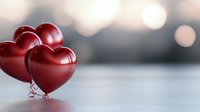 Red heart-shaped balloons against blurred bokeh background, romantic Valentine's Day concept with soft focus and copy space for love message or greeting card design.