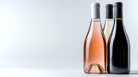 Elegant wine bottles collection featuring rose, white and red wines arranged on reflective surface against light background, showcasing variety in wine styles.