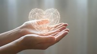 Hands holding glowing geometric heart symbol representing love, care, healthcare, charity, donation, compassion and human connection concept.