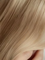 Smooth flowing blonde hair texture with natural gradient from darker to lighter tones, showcasing silky strands and healthy shine. For beauty and haircare advertising.