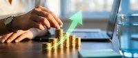 Businesswoman stacking gold coins on desk with glowing green arrow showing financial growth, investment success, and wealth increase concept.