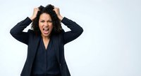 Frustrated African American businesswoman pulling hair screaming in anger wearing dark blazer on white background isolated for design use.