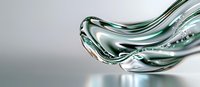 Flowing liquid metal wave with green tint creates dynamic abstract shape against light background, showcasing modern fluid motion design for technology concepts.
