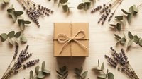 Kraft paper gift box with twine bow surrounded by dried lavender sprigs and eucalyptus leaves on wooden background for natural packaging design.