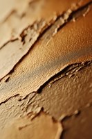 Closeup of layered tan and brown textured surface with dimensional brushstrokes and shadows, suitable for backgrounds, design elements, and artistic projects.