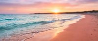 Serene coastal landscape with soft pink sand beach, gentle turquoise waves, and golden sunset sky reflecting on calm ocean waters, perfect for travel and relaxation themes.