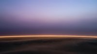 Earth horizon at sunrise from high altitude with golden light band across dark landscape below, suitable for space, astronomy, and travel backgrounds.