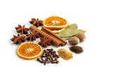 Aromatic spices and dried orange slices arranged on white background including cinnamon sticks, star anise, bay leaves, cloves and nutmeg for cooking.