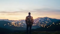Silhouette of man against sunset sky with glowing network visualization overlay, mountains in background creating inspiring technology concept.
