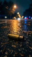 Brass bullet casing on wet asphalt street at night with bokeh lights and rain drops creating dramatic urban crime scene atmosphere.