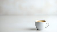 White coffee cup with fresh espresso on clean minimalist background with copy space for text and design projects.