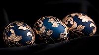 Elegant Easter eggs with deep blue matte finish and ornate golden floral pattern on dark background showcase traditional holiday decorative art.