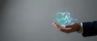 Businessman hand holding glowing heart with heartbeat pulse line symbol, representing healthcare, medical insurance, cardiology, and wellness concept for digital health services.