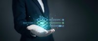 Businessman holding holographic digital interface with futuristic data visualization and glowing elements for technology presentations and corporate materials.