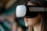 Young Asian woman wearing virtual reality headset with focused expression against blurred background, exploring immersive digital experience.